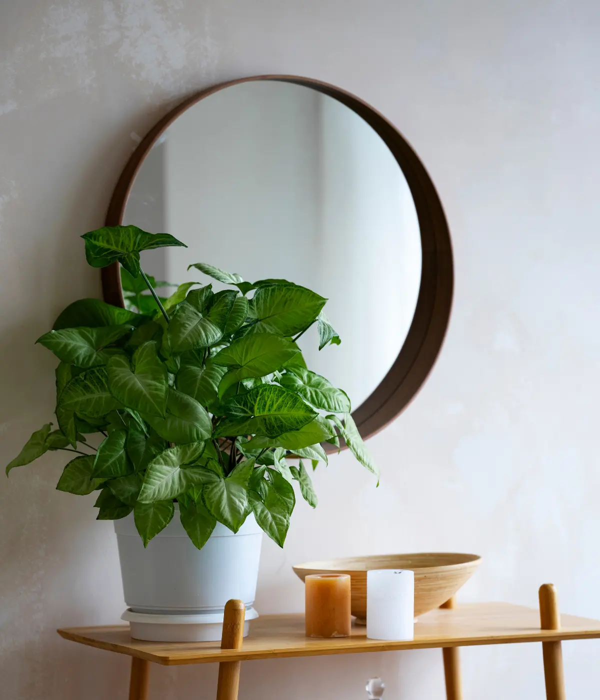 Miroir rond au-dessus d’une console dans une entrée claire