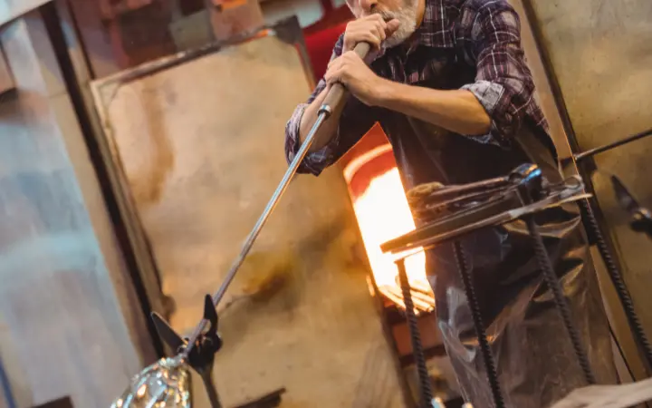 Artisan souffleur de verre en atelier avec four à haute température