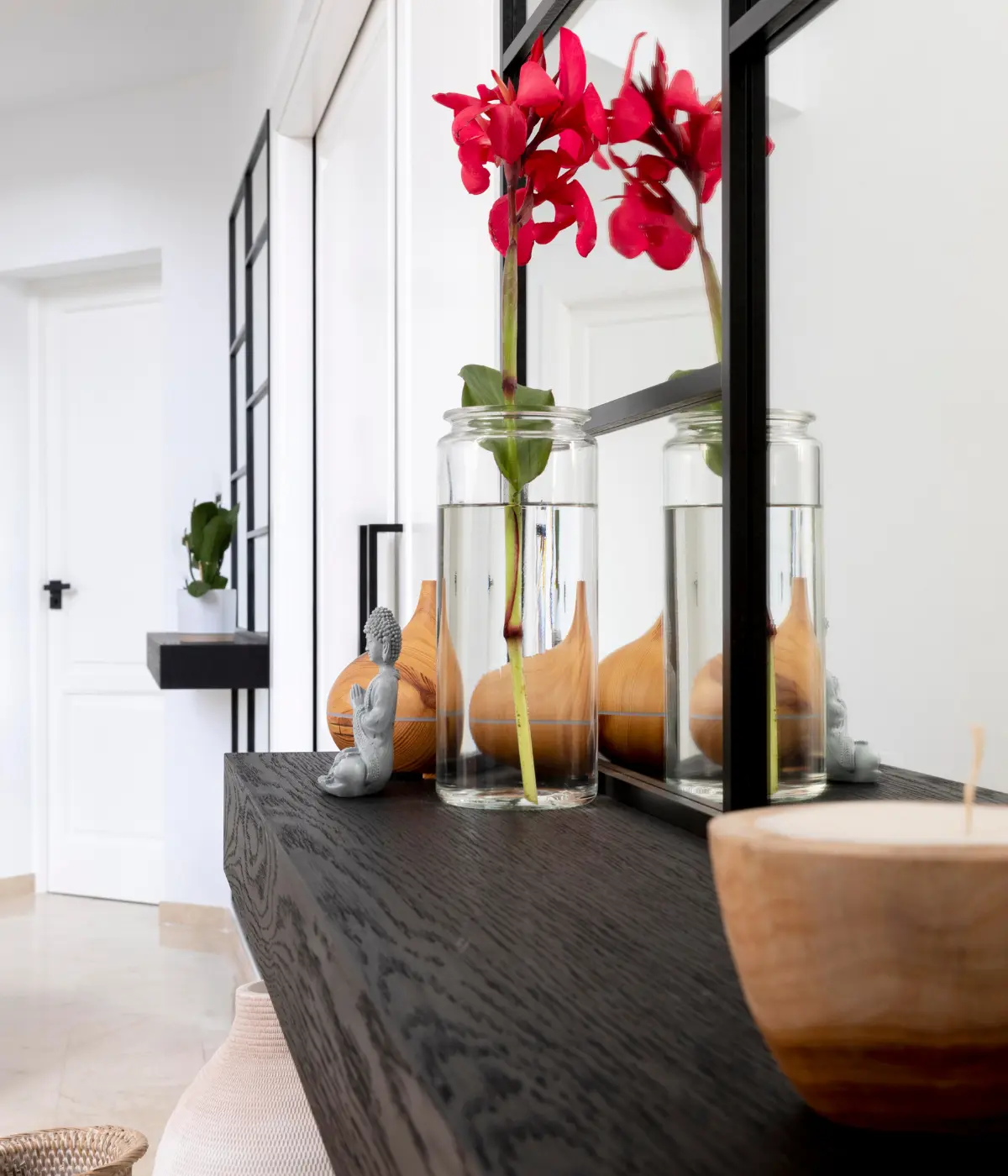 Grand miroir panoramique dans un salon lumineux au-dessus d’un meuble bas